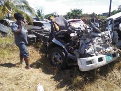 A man looks at the wrecked Isuzu motor truck which was being driven by former police sergeant Christopher McDaniel. Sugar cane that was being transported by another truck fell on the vehicle, crushing McDaniel.