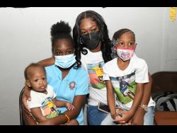 Bobbette Shelton, the widow of Luton Shelton, with their children (from left) King, Lutasha, and Azaria, at the viewing of her late husband’s body at the House of Tranquillity Funeral Home on Orange Street, in Kingston, yesterday.