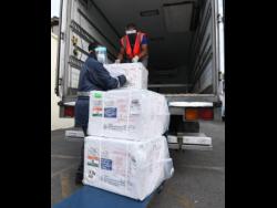 Staff of the National Health Fund removing boxes of the COVID-19 vaccine at the organisation’s warehouse on Monday.