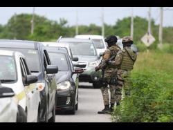 Members of the Jamaica Defence Force during an operation on the Hellshire  main road in St Catherine last October. Prime Minister Andrew Holness said that the security forces will be robust in enforcing breaches of the Disaster Risk Management Act, the key tool used in the fight against COVID-19.