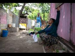 Denise Burrell speaks about the death of her cousin, Millicent Robinson, whose body was found in a shallow grave in her yard in Craig Town, St Andrew, on Sunday. 