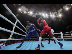 Cristian Salcedo of Colombia (right) throws a punch to Ricardo Brown of Jamaica during the second round of their men’s heavy 91kg semi-final boxing match at the Pan American Games in Lima, Peru, in July 2019. 