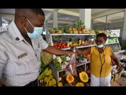 Ermine Reddy sells food items to a member of the Jamaica Constabulary Force.