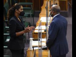 Tourism Minister Edmund Bartlett speaks with Lisa Hanna, Opposition spokesperson on the portfolio before the start of the Sitting of Parliament on Tuesday in Gordon House, Kingston.