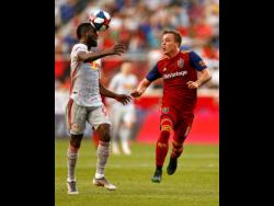 New York Red Bulls defender Kemar Lawrence heads the ball in front of Real Salt Lake forward Corey Baird during the first half of an MLS match in June 2019 in Harrison, New Jersey.
