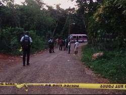 Police cordon the crime scene near the entrance to the Meadowrest Memorial Gardens in St Catherine. Two women were killed when gunmen shot up a bus transporting mourners from a burial.