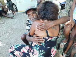 Rupert Wachope comforts one of his nieces, Keisha Silvera, as she tries to come to terms with the passing of her father, Leric Silvera. 