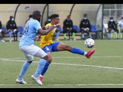 Harbour View’s Oquassa Chong (right) controls the ball while being tackled by  Shawn Dewar of Waterhouse during their Jamaica Premier League match at the UWI Captain Horace Burrell Centre of Excellence on Monday. The match ended 1-1. 