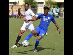 Nicholas Nelson (right) of Molynes United turns away from Mount Pleasant’s  Liston James during yesterday’s Jamaica Premier League match at the UWI/Captain Horace Burrell Centre of Excellence.