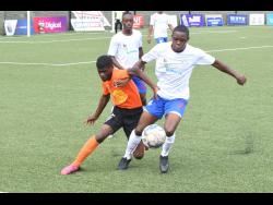 Seigel Knight (right) of Portmore United getting away from Tivoli Gardens’  Horatio Morgan during yesterday’s Jamaica Premier League match at the UWI/Captain Horace Burrell Centre of Excellence.