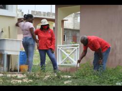 Racquel Reid-Simpson (centre), National Water Commission’s wastewater supervisor, oversees an investigation of a residence during the tour.
