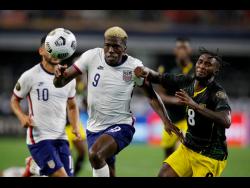 United States forward Gyasi Zardes (9) powering his way past Jamaica’s Oniel Fisher (8)  in the second half of last night’s Concacaf Gold Cup quarter-final  in Arlington, Texas. United States won 1-0. 