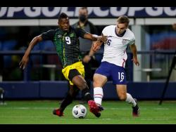 Jamaica forward Cory Burke (9) and United States defender James Sands (16) compete for control of the ball in the first half of  their Gold Cup quarter-final match on Sunday in Arlington, Texas. The United States won 1-0.