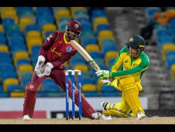 Australia batsman Alex Carey (right) plays a shot while West Indies wicketkeeper Shai Hope looks on during their third and final one-day international, at the Kensington Oval in Bridgetown, Barbados, yesterday.