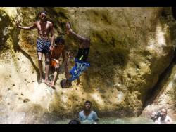 Rohan Wilson is full flight at Cane River Falls in St Andrew yesterday.