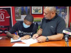 Reggae Boy Leon Bailey (left) made his move to the English Premier League Club official yesterday when he signed a contract with Aston Villa Football Club. The signing took place at  the Phoenix Academy headquarters in Kingston. Looking on is his father and agent Craig Butler.