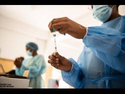 A public health nurse prepares a dose of the Oxford-AstraZeneca vaccine for the inoculation of a senior citizen at The Golden Age Home in Kingston on March 23.