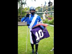 Credit: Anthony Minott Dick Cardenas indicates riding a handful of winners after scoring aboard his fifth winner, CURLIN’S FLIGHT, in the 10th race at Caymanas Park on Saturday.