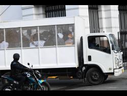Alleged members of the One Don faction of the Clansman Gang being transported to the Home Circuit Court in Kingston.