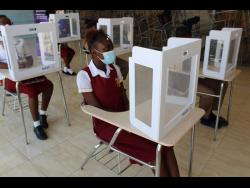 Students of Denham Town High School in Kingston sit at their desks, which were outfitted with desk shields, following the brief reopening of schools to face-to-face learning last year.