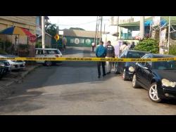 Police cordon off the crime scene where gunmen shot up a Toyota Mark X motor car, killing three men.