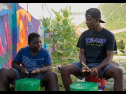 Renaldo Jackson, 13, (left) and Shaquael Grant, 15, drum a beat at Freedom Skatepark in Bull Bay, St Andrew, on Saturday.
