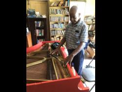 Albert Wellington tunes a piano.
