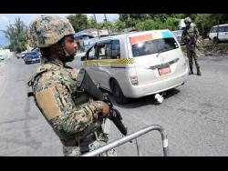 Members of the security forces carry out checks at a state of public emergency checkpoint on Maxfield Avenue in St Andrew.