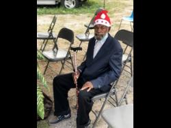 George Dixon waits to receive his care package from the Salvation Army donation centre on Lyndhurst Road in St Andrew yesterday.