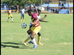 Credit: Ashley Anguin St. Andrew Technical High School’s (STATHS) Omar Laing (back) tackles his opponent Dinthill Technical’s Daniel Roberts during an ISSA Champions Cup match at the STETHS Sports Complex in Santa Cruz, St Elizabeth yesterday.