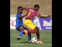 Dinthill Technical’s Jahiem Thomas (right) is challenged by Jamaica College’s Saviola Blake during their ISSA Champions Cup match at Stadium East in Kingston on Saturday.