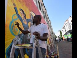 Sheldon Blake paints a piece, titled ‘Indian Melodies’, along Water Lane in downtown Kingston.
