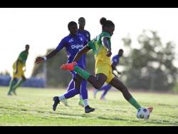 Excelsior High School’s Joel Jones (right) goes for a long pass while challenged by Kingston College’s Ronardo Burgher in their ISSA/Digicel Manning Cup quarter-final match, held at the  Ashenheim Stadium in St Andrew on Saturday, December 18, 2021. 