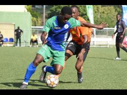 Montego Bay United’s Devrow McKenzie (left) dribbles away from Trevin Garnett of Tivoli Gardens during yesterday’s Jamaica Premier League match at the UWI-JFF Captain Horace Burrell Centre of Excellence. The game ended in a 1-1 draw. 
