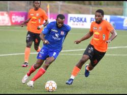 Dunbeholden’s vice-captain Fabion McCarthy (left) dribbles away from Tivoli Gardens FC’s Rickardo Oldham during their Jamaica Premier League match at the UWI-JFF Centre of Excellence yesterday.