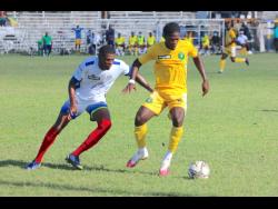 Vere United’s Travis Grant (right) moves away from Portmore United’s Gawain Austin during their Jamaica Premier League encounter at Drax Hall in St Ann yesterday.