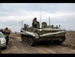 A cameraman films as an armoured vehicle rolls outside Mykolaivka, Donetsk region, the territory controlled by pro-Russian militants, eastern Ukraine on Sunday. Fighting also raged in two eastern territories controlled by pro-Russia separatists.