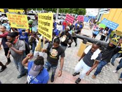 Persons participate in the United Independents’ Congress-led protests in downtown Kingston last September.