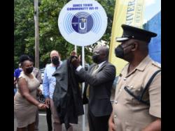 Louise Newland (left), a resident in Admiral Town, participates in the commissioning of a Wi-Fi hotspot at the Jones Town Primary School in St Andrew last Friday.Sharing in the moment are: Mark Golding (second left), leader of the Opposition and member of parliament, St Andrew Southern; Daniel Dawes (second right), CEO, Universal Service Fund; and Senior Superintendent of Police Michael Phipps.