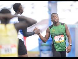 Dishaun Lamb (right) of Calabar High being congratulated by Sandrey Davison of St Catherine High after winning heat five of the Class Two 100 metres dash on day three of the 2019 ISSA/GraceKennedy Boys and Girls’ Athletics Championships in 2019.