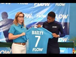 Flow’s new brand ambassador, Reggae Boy Leon Bailey, is presented with a Flow jersey by Senior Director of Marketing Sara Martins De-Oliveira at a small ceremony held at AC Hotel, St Andrew, yesterday. 