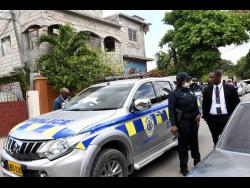 Police personnel outside the home of reggae singer Donald ‘Tabby Diamond’ Shaw, who was murdered on Tuesday night by a lone gunman who attacked a group of persons.