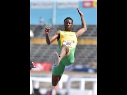 St Jago High School’s Balvin Israel midflight during the Class Two Boys Long Jump final at the ISSA/GraceKennedy Boys and Girls Athletics Championships at the National Stadium yesterday.