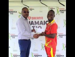 Surrey Risers batter Delbert Gayle (right) accepts the Man of the Match cheque from Jamaica Cricket Association Chief Executive Officer Courtney Francis after the team’s win in the Dream11 Jamaica T10 competition at Sabina Park in Kingston yesterday.