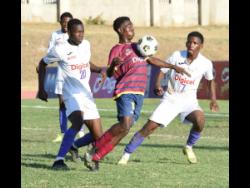 In this file photo from November 2021, St Andrew Technical High School’s Omar Laing (centre) takes the ball down while under pressure from Kingston College players Taraj Andrews (left) and Gavin Burton during an ISSA/Digicel Manning Cup game at Stadium East. Laing was murdered in a drive-by shooting in his community last Friday.