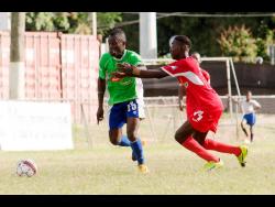 In this file photo from January 2018, Montego Bay United’s Dwayne Ambusley (left) shrugs off Boys Town’s Shaquille Bradford to keep possession of the ball during their Jamaica Premier League game at the Barbican Sports Complex.