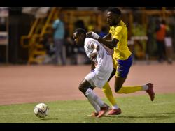 Mount Pleasant’s Donovan Segree (left) is challenged by Molynes United’s Jermy Nelson during their Jamaica Premier League match at Stadium East in St Andrew last night.