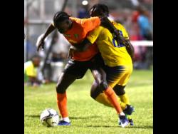 Tivoli Gardens’ Diego McKenzie (left) tussles for the ball with Molynes United’s Jevaughn Brown during their Jamaica Premier League game at the Anthony Spaulding Sports Complex in Kingston last night.