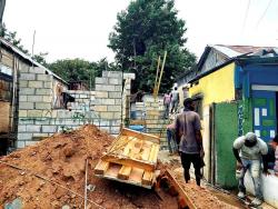 Workmen erect a dwelling for one of the beneficiaries of a housing project.