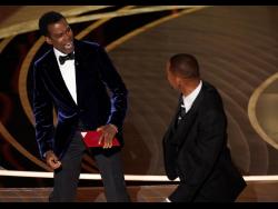 Chris Rock (left) reacts after being hit on stage by Will Smith at the Oscars in March.
